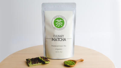 bag of mizuba culinary matcha with whisk and matcha candy bar pieces on table